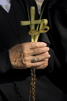 Israeli Prints: Close up of a nuns hands holding two crosses made of palm leaves