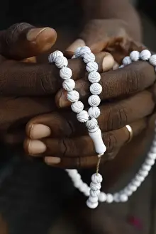 Adults Prints: Close-up of hands of African Muslim man praying with Islamic prayer beads (tasbih), Togo