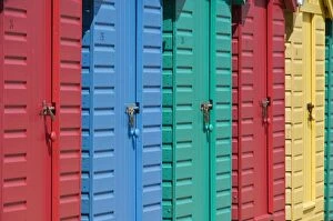 Repeating Collection: Close-up of multicoloured beach huts on the long sweeping beach of Llanbedrog