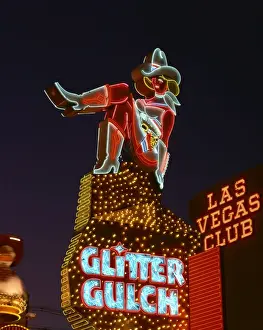 Night Life Prints: Close-up of neon sign of a cowgirl advertising Glitter Gulch at night in Las Vegas