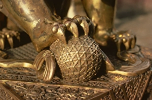Claw Prints: Close-up of the paw of a gilt bronze lion holding a fire ball, symbol of force
