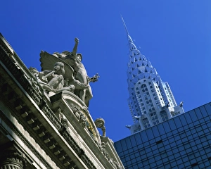 Close-up of statues on top of Grand Central Station, with the Chrysler Building in the background Close-up of statues on top of Grand Central Station, with the Chrysler Building in the background