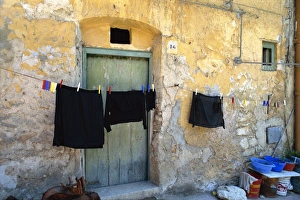 Clothes on a washing line outside an old house with