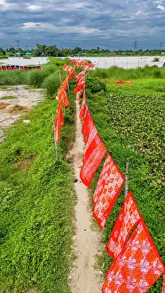 Hanging Prints: Cloths drying on a path in rural Bangladesh under cloudy skies in the village of Araihazar