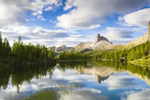 Clouds over Becco di Mezzodi reflected in the blue water of Lake Federa at sunrise