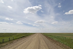 Clouds and blue sky over a dirt track in the Badlands of Alberta, near Drumheller