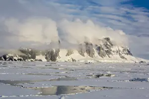 Ice Floe Prints: Clouds forming over snow-capped mountains in Penola Strait, Antarctica, Polar Regions