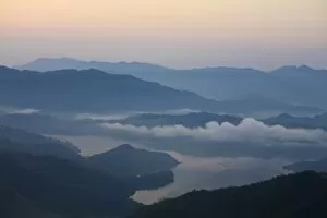 Clouds hover over lake at sunrise, Sikles trek, Pokhara, Nepal, Asia