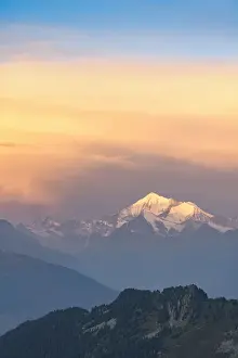 Clouds in the misty sky at dawn over Matterhorn and snow capped Weisshorn peak