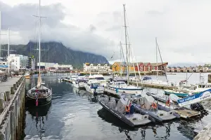 Svolvaer Prints: Clouds on rocky peaks frame the boats in the harbor of the fishing village of Svolvaer