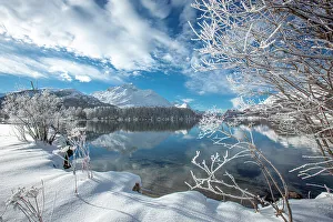 Engadine Prints: Clouds over snowy woods on shores of frozen Lake Sils in winter