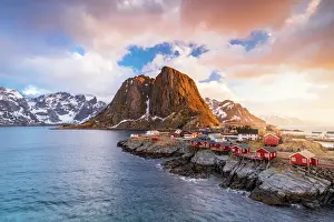 Hamnoy Prints: Clouds at sunrise over traditional Rorbu cottages on cliffs by the cold arctic sea