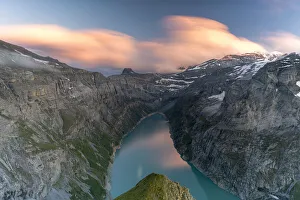 Clouds at sunset over the pristine lake Limmernsee and mountains, aerial view