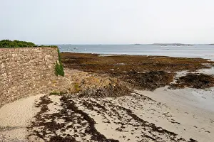 Retreat Prints: Coastal stone wall meets sandy tidal flats at Rocquaine Bay in Guernsey