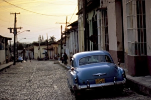Hispanic Prints: Cobbled street at sunset with old American car, Trinidad, Sancti Spiritus province