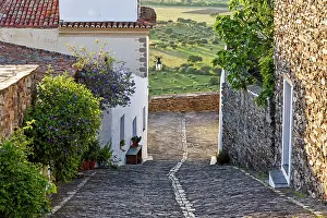 Small Prints: Cobbled street winding through the village of Monsaraz in Portugal showcasing local architecture