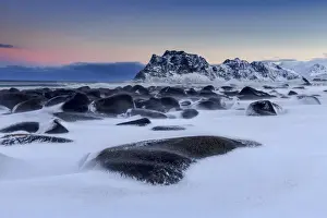 Windswept Prints: The cold wind that blows constantly shapes the snow on the rocks around Uttakleiv at dawn