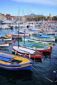 Docked Prints: Colorful boats fill Nice Port near the water with yachts and buildings in the background in Cote dAzur