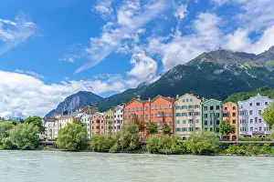 Innsbruck Prints: Colorful buildings line the banks of River Inn under a blue sky in summer in Tyrol region of Austria