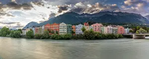 Innsbruck Prints: Colorful buildings along River Inn at sunset with mountains in the background during summer in Tyrol Region