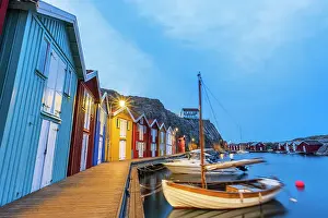 Sweden Prints: Colorful fishing huts with wooden boat moored at the jetty at dusk