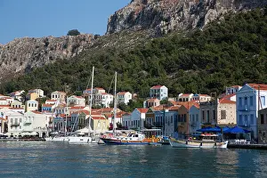 Sailboats Prints: Colorful houses and boats line the harbor in Megisti Bay