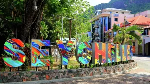 Bright Prints: Colorful Seychelles sign welcomes visitors to Mahe with vibrant design and tropical scene