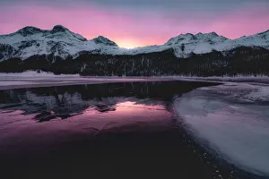 Engadine Prints: Colorful sky at sunrise on snowcapped mountains and frozen Lake Silvaplana, Maloja