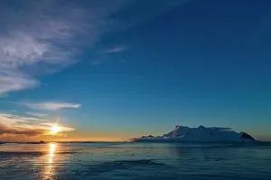 Antarctica Prints: Colorful sunset skies reflect on the water near Stonington Island in Antarctica