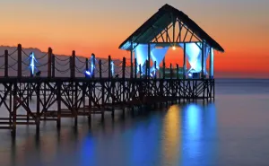 Azure Prints: Colorful sunset view from the pier near the water at Pointe aux Piments in Mauritius with lights illuminating