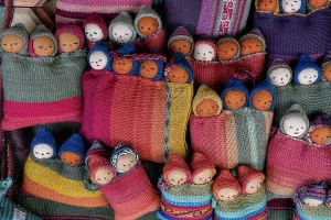 Creativity Prints: Colorful textiles and handcrafted dolls displayed at traditional center in Chinchero