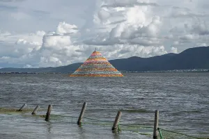 Pyramid Prints: Colorful Tibetan stupa stands in Napa Lake with mountains and clouds in the background near Shangri-La in Yunnan