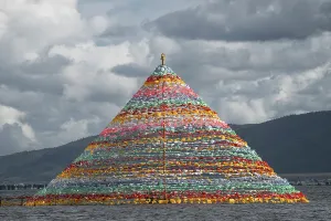 Stupa Prints: Colorful Tibetan stupa stands on Napa Lake as prayer flags flutter under cloudy skies in China