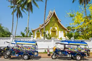 Taxi Prints: Colorful tuk-tuks in front of Haw Pha Bang temple on the grounds of the Royal Palace