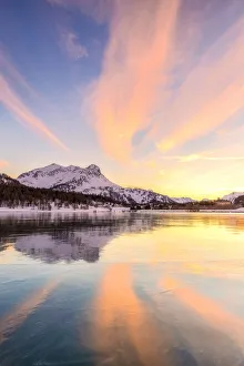 Colors of sunset reflected on the icy surface of Lake Sils, Engadine Valley, Graubunden
