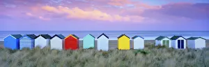 Suffolk Prints: Colourful beach huts and sand dunes at sunset, Southwold, Suffolk, England, United Kingdom