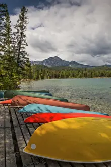 Alberta Prints: Colourful canoes and kayaks on the bank of Annette Lake with Pyramid Mountain in the background