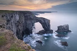 Natural Arch Prints: Colourful dawn sky above the Green Bridge of Wales natural arch in Pembrokeshire, Wales