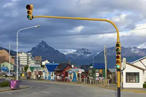 Argentinean Prints: Colourful houses on touristic road framed by traffic lights post with snowy mountain chain beyond