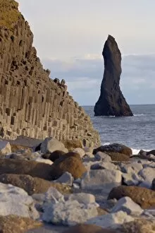 Columnar basalt cliffs and Reynisdrangar sea stack standing in the sea