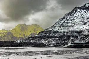 Volcano Prints: Contrast of black volcanic plains and moss-covered peaks near Katla glacier in Iceland during glacial melt season