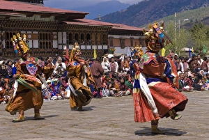 Images Dated 7th April 2009: Costumed dancers at religious festival with many visitors, Paro Tsechu