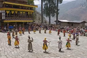 Images Dated 7th April 2009: Costumed dancers at religious festival with many visitors, Paro Tsechu
