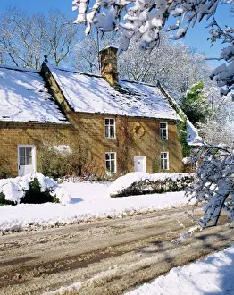 Cottage Prints: Cotswold farmhouse beside a road covered in snow in winter in England
