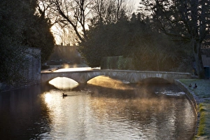 Cotswold stone bridge over River Windrush in mist, Bourton-on-the-Water, Cotswolds