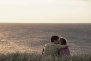 Couple kissing on cliff overlooking Pacific Ocean at South Point
