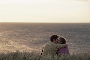 Couple kissing on cliff overlooking Pacific Ocean at South Point Couple kissing on cliff overlooking Pacific Ocean at South Point