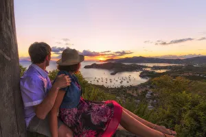 35 39 Years Gallery: Couple look to the English Harbor from Shirley Heights at sunset, Antigua, Antigua and Barbuda