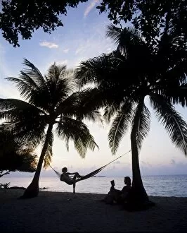 Images Dated 9th August 2010: Couple relaxing on a beach at sunset, Maldives, Indian Ocean, Asia