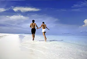 Couple Prints: Couple running on a beach, Maldives, Indian Ocean, Asia